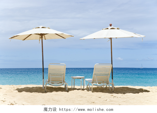 沙滩上的躺椅和太阳伞两个白色的沙滩椅和遮阳伞